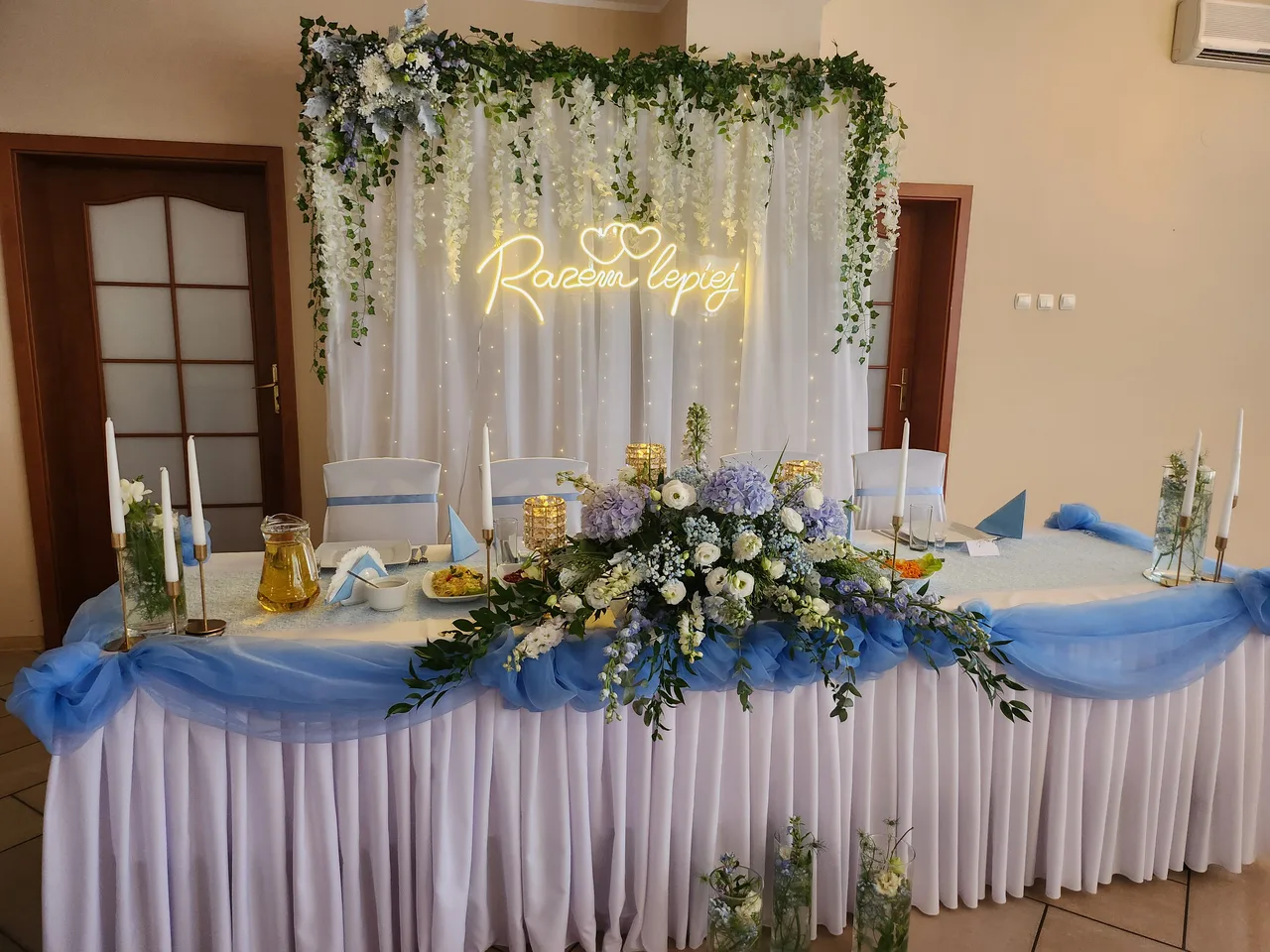 Stół pary młodej z dekoracją kwiatową i napisem świetlnym w sali weselnej hotelu Dowhań